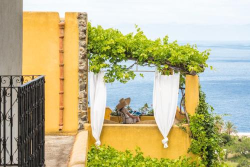 a gazebo with white curtains and a view of the ocean at Hotel Ravesi in Malfa