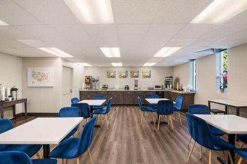 a classroom with tables and chairs and a kitchen at SureStay Plus Hotel by Best Western SeaTac Airport in SeaTac