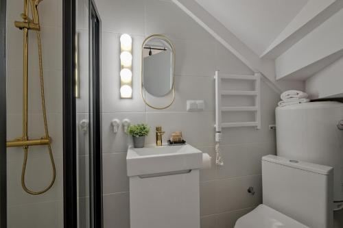 a white bathroom with a sink and a mirror at Domek Tatary Odkryj Zakopane in Zakopane