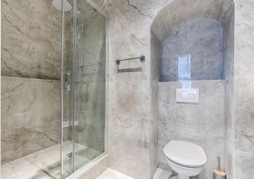 a bathroom with a toilet and a glass shower at Zen & Luxury 2BR Flat - Eiffel Tower in Paris