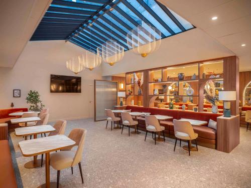 a restaurant with tables and chairs and a bar at Novotel Orléans Centre Gare in Orléans