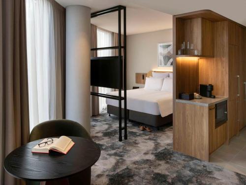 a hotel room with a bunk bed and a table with a book at Pullman Sydney Penrith in Penrith
