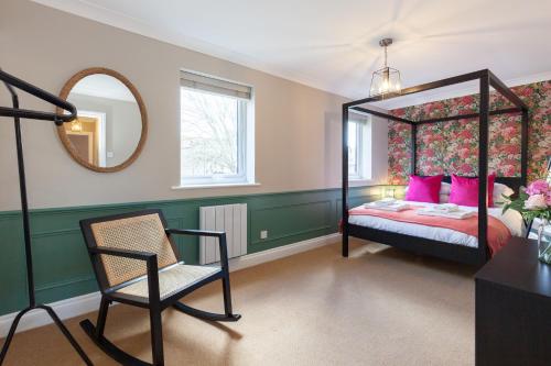 una camera con letto a baldacchino e sedia di A gem nestled in the heart of Oxford with parking! a Oxford