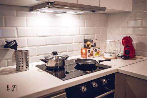 una cucina con piano cottura e pentole. di 5Torres Apartment a Madrid