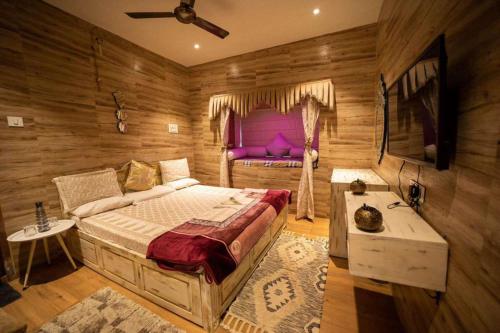 a bedroom with a large bed and a purple couch at The ABU ltaliano in Mount Ābu