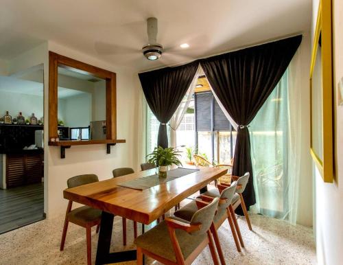 a dining room with a wooden table and chairs at Rumah Satu by NK in Alor Setar
