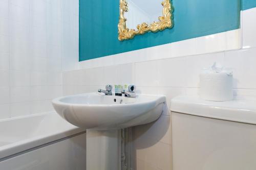 a white bathroom with a sink and a mirror at A gem nestled in the heart of Oxford with parking! in Oxford