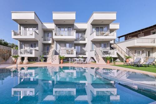 an apartment building with a swimming pool in front of it at Superior family apartment w/pool dining area in Stavromenos
