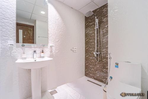 a white bathroom with a sink and a shower at Lawnz-4 210 in Dubai