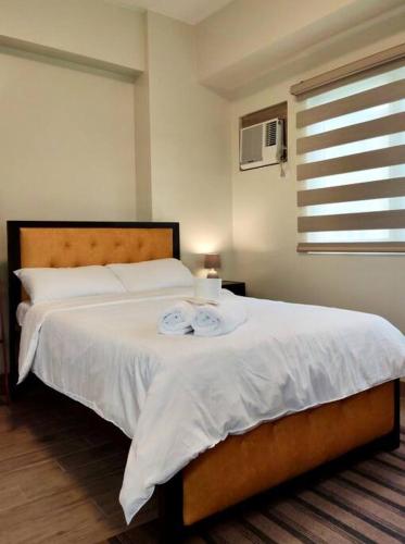 - une chambre avec un lit et 2 serviettes dans l'établissement Cozy studio w/ Nintendo Switch, à Bacolod