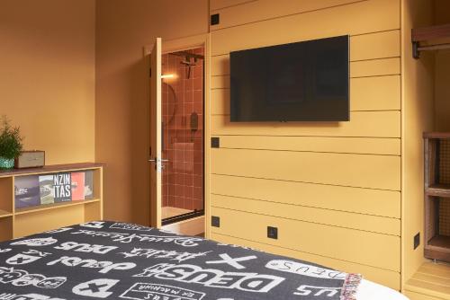 1 dormitorio con TV de pantalla plana y 1 cama en Deus Lodge of Heavy Leisure en Bournemouth