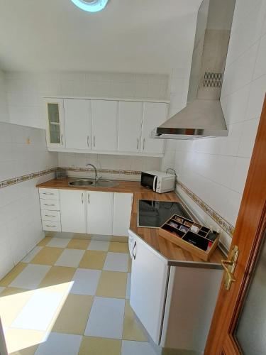 a small kitchen with white cabinets and a sink at Banda playa 82, en pleno corazón de Sanlucar in Sanlúcar de Barrameda