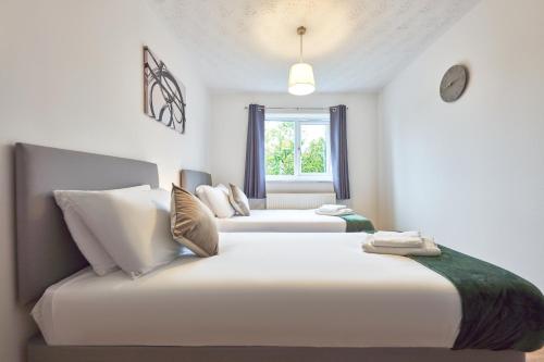 Loughton的住宿－3 Bedroom Home in Central Milton Keynes，一间卧室设有两张床和窗户。
