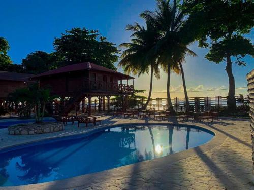 a resort swimming pool with a gazebo and palm trees at Hotel Sea Breeze in Paraíso