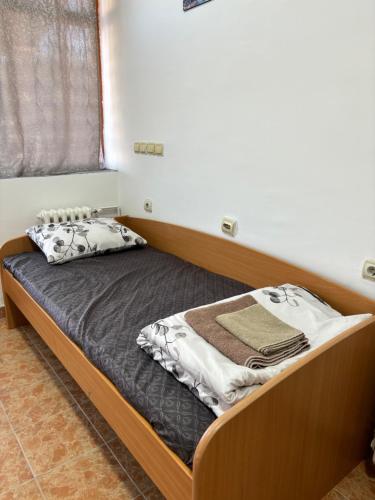 uma cama com uma estrutura de madeira num quarto em Apartman Stil em Kruševac