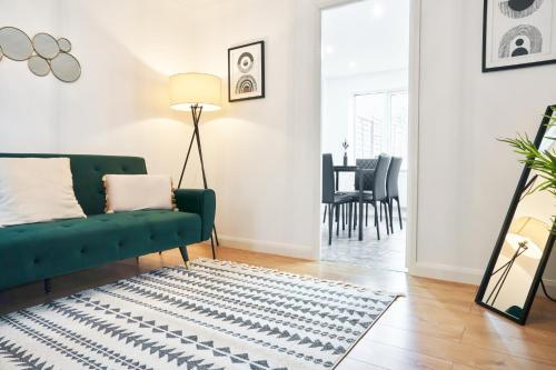 a living room with a green couch and a rug at 3 Bedroom Home in Central Milton Keynes in Loughton