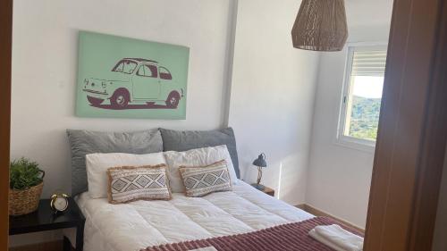 Schlafzimmer mit einem Bett mit einem Van-Bild an der Wand in der Unterkunft Villaterramarina in Finestrat