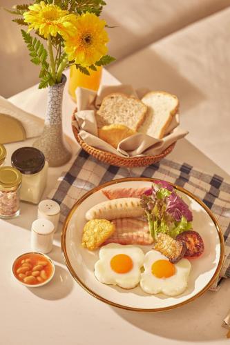 a plate of food with eggs and bread on a table at CHINO@NIMMAN Luxury Boutique Hotel in Chiang Mai