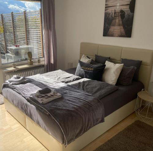 1 cama en un dormitorio con ventana grande en FerienwohnenAmSee Penthouse mit Whirlpool, en Überlingen