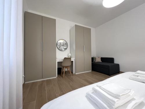 a white bedroom with a bed and a desk at Comfort Zone in Mestre