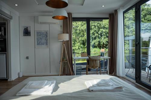 een slaapkamer met een bed en een groot raam bij 80qm privates Hausboot in Hamburg-Mitte in Hamburg