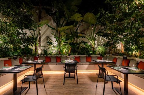 a restaurant with tables and chairs and plants at Ivis 4 Boutique Hotel in Athens