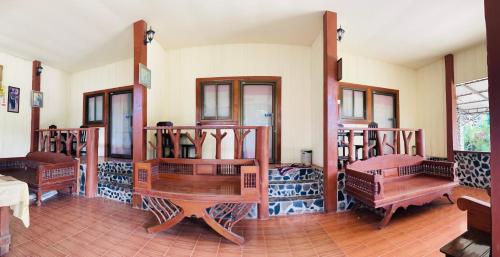 Zimmer mit Holztischen und Bänken in einem Zimmer in der Unterkunft Lungsonhouse in Pai