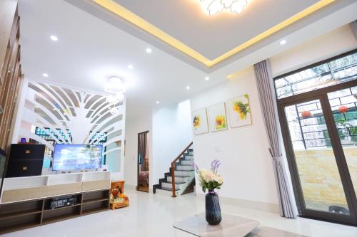 un soggiorno con TV e soffitto di Nhà riêng có 4 phòng ngủ - Kennpi Aparment a Hue
