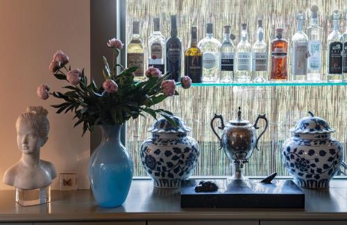 un groupe de vases assis sur une table avec une fenêtre dans l'établissement Hotel Franceschi, à Forte dei Marmi