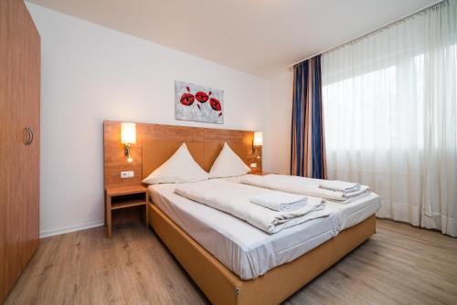 a bedroom with a large bed with white sheets at G & L Hotel Dortmund in Dortmund