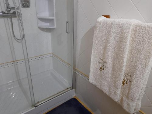 a bathroom with a shower and a white towel at Tapada do Padre Rosa in Vila Viçosa