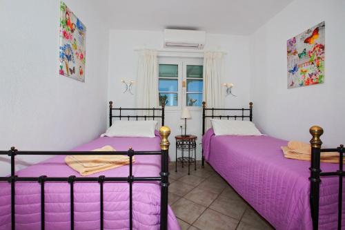 2 camas en una habitación con sábanas moradas en Villa Marcus - 3 Bedrooms large pool plus childs pool - Great for families en Puerto del Carmen