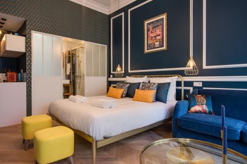 une chambre avec un grand lit et un canapé dans l'établissement The Champs Elysées Blue Suite, à Paris