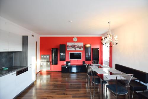 a dining room with red walls and a table and chairs at schöne, vollausgestattete 90m2 Wohnung mit drei Zimmern am Land 