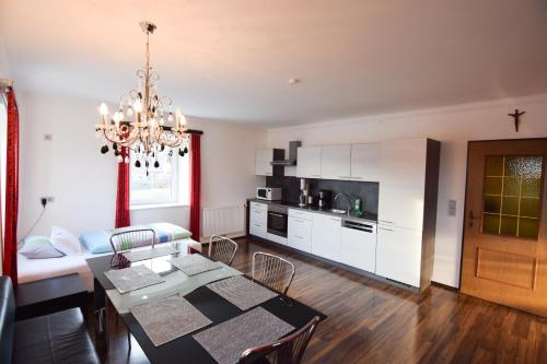 a living room with a dining table and a kitchen at schöne, vollausgestattete 90m2 Wohnung mit drei Zimmern am Land 