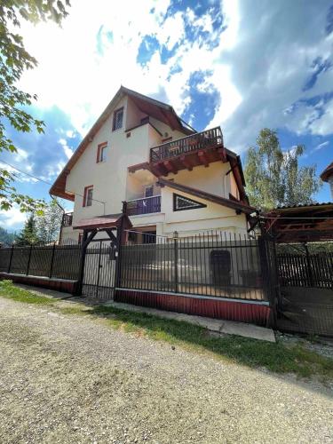 a large house with a fence in front of it at Celesta Trei Brazi in Predeal