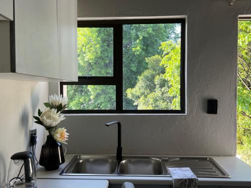 a kitchen counter with a sink and a window at Cosy Nest 5 min to Sandton City 16 in Johannesburg