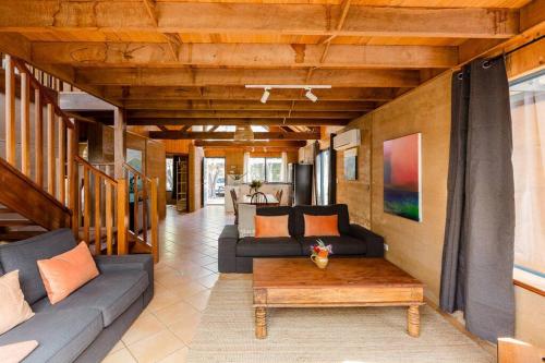 a living room with couches and a coffee table at Beachy Sleeps! Eco Friendly Family Retreat in Prevelly