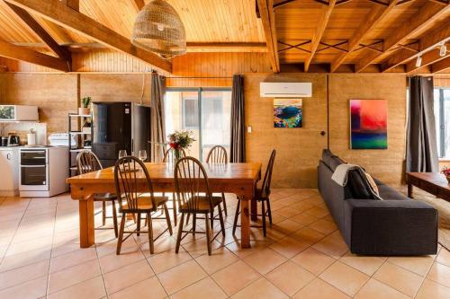 a dining room with a table and a couch at Beachy Sleeps! Eco Friendly Family Retreat in Prevelly
