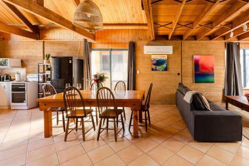 comedor con mesa y sofá en Beachy Sleeps! Eco Friendly Family Retreat en Prevelly