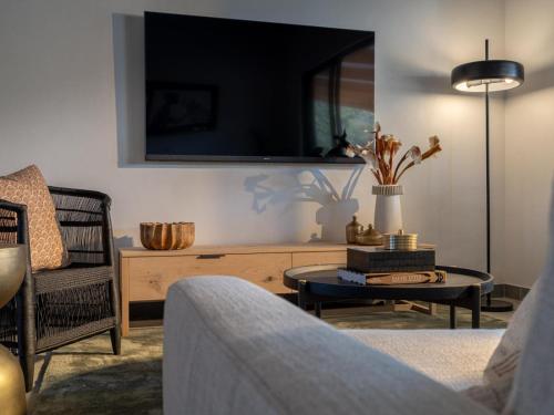 a living room with a tv and a table at Nomads Den Safari Villas - Heated Pools and Riverbed views in Hoedspruit