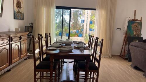 un comedor con una mesa con sillas y una ventana en Casa Zitouna - Guest House - Kef, Tunisia, en Sicca Veneria
