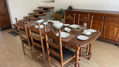 una mesa de comedor de madera con platos y vasos. en Casa Zitouna - Guest House - Kef, Tunisia, en Sicca Veneria