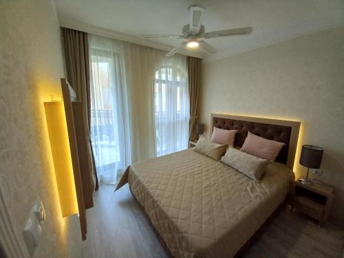 een slaapkamer met een bed en een plafondventilator bij Private Apart in Sveti Vlas Harmony Suite in Sveti Vlas