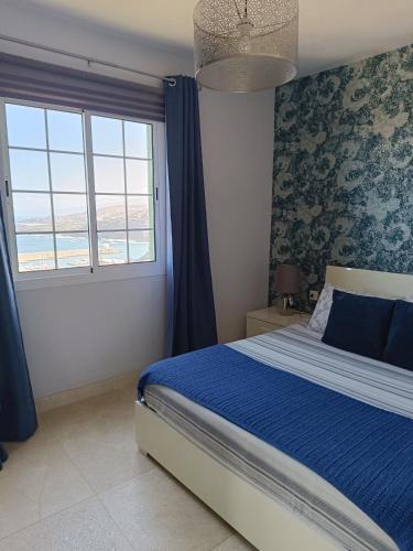 a bedroom with a bed and a large window at La Casita de Brownie in Garachico