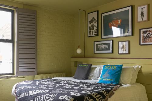 a bedroom with a bed in a yellow wall at Deus Ex Machina Hotel in Bournemouth