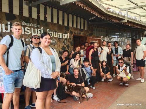 ein Mann und eine Frau stehen vor einer Menschenmenge in der Unterkunft Ban Mae Arom in Amphawa
