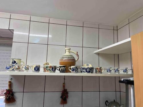 a shelf with cups and a kettle on it in a kitchen at Cabana Celesta in Predeal