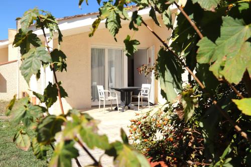 a patio with a table and chairs in front of a house at Hotel Restaurant La Dame du Lac in Monflanquin