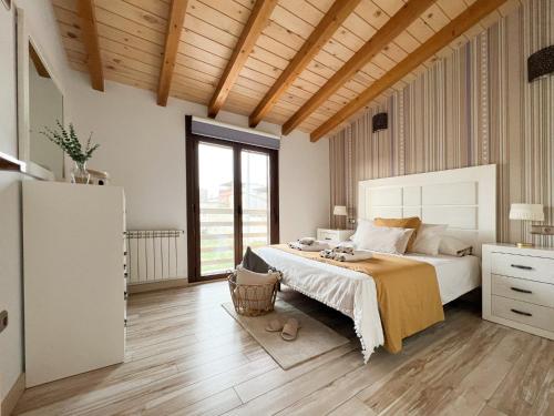 a bedroom with a large bed and a large window at CASA VISTA SIERRA in Jaraiz de la Vera